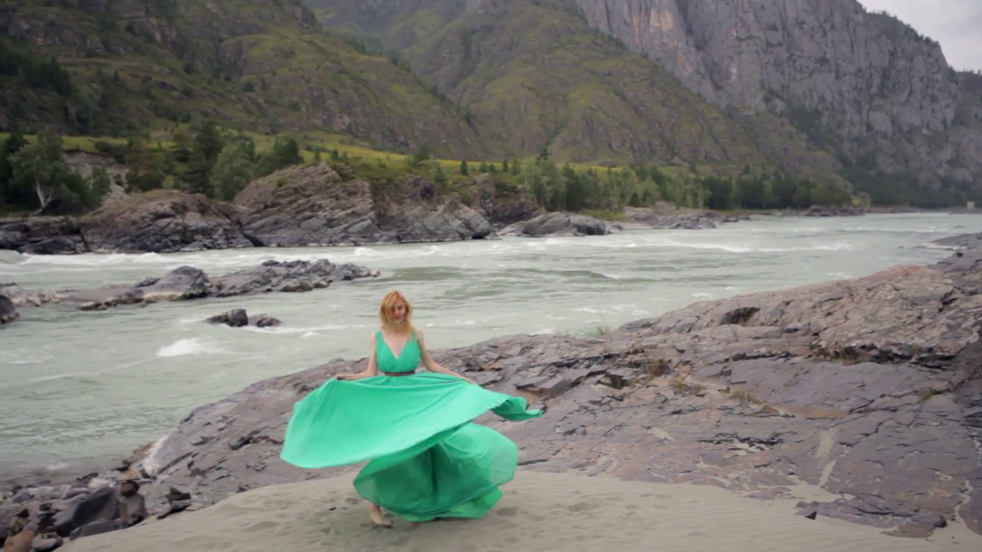 beautiful girl in a green dress on the bank of a mountain river Stock ...
