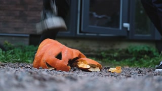 close-up teenagers kicking a halloween pumpkin