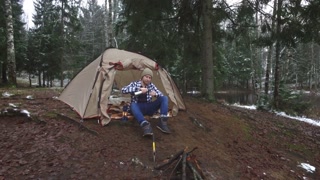 the tourist drinks tea in a tent on the lake shore