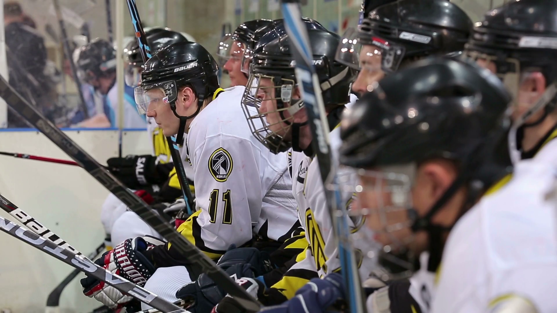 Hockey players sit on bench and root for their team. Stock Video
