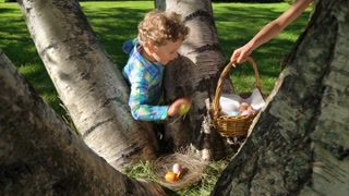 Two children boy and girl having easter egg hunt in garden backyard