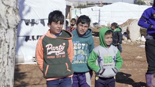 January 2017 - Beqaa Governorate, Lebanon: Syrian children smile and wave to camera at a refugee camp