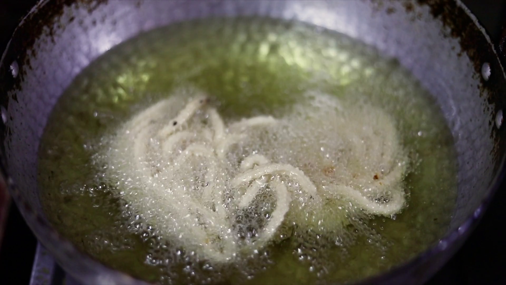 indian snack prepared during diwali festival in india is frying in hot oil. photo