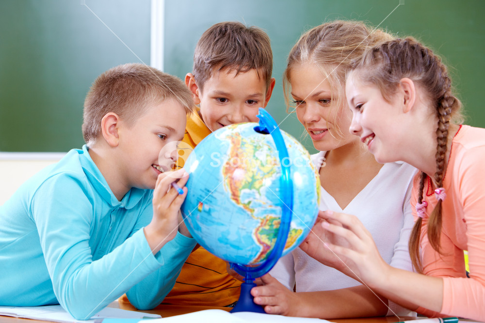 Portrait Of Adorable Students and Teacher Exploring Globe in Classroom