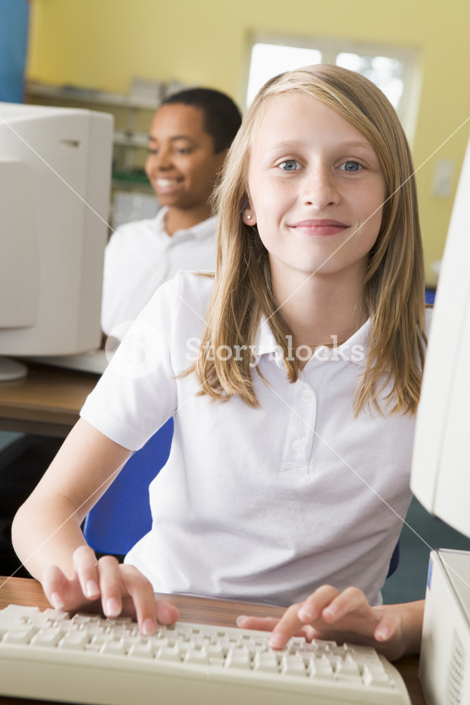Schoolgirl studying in front of a school computer RoyaltyFree Stock